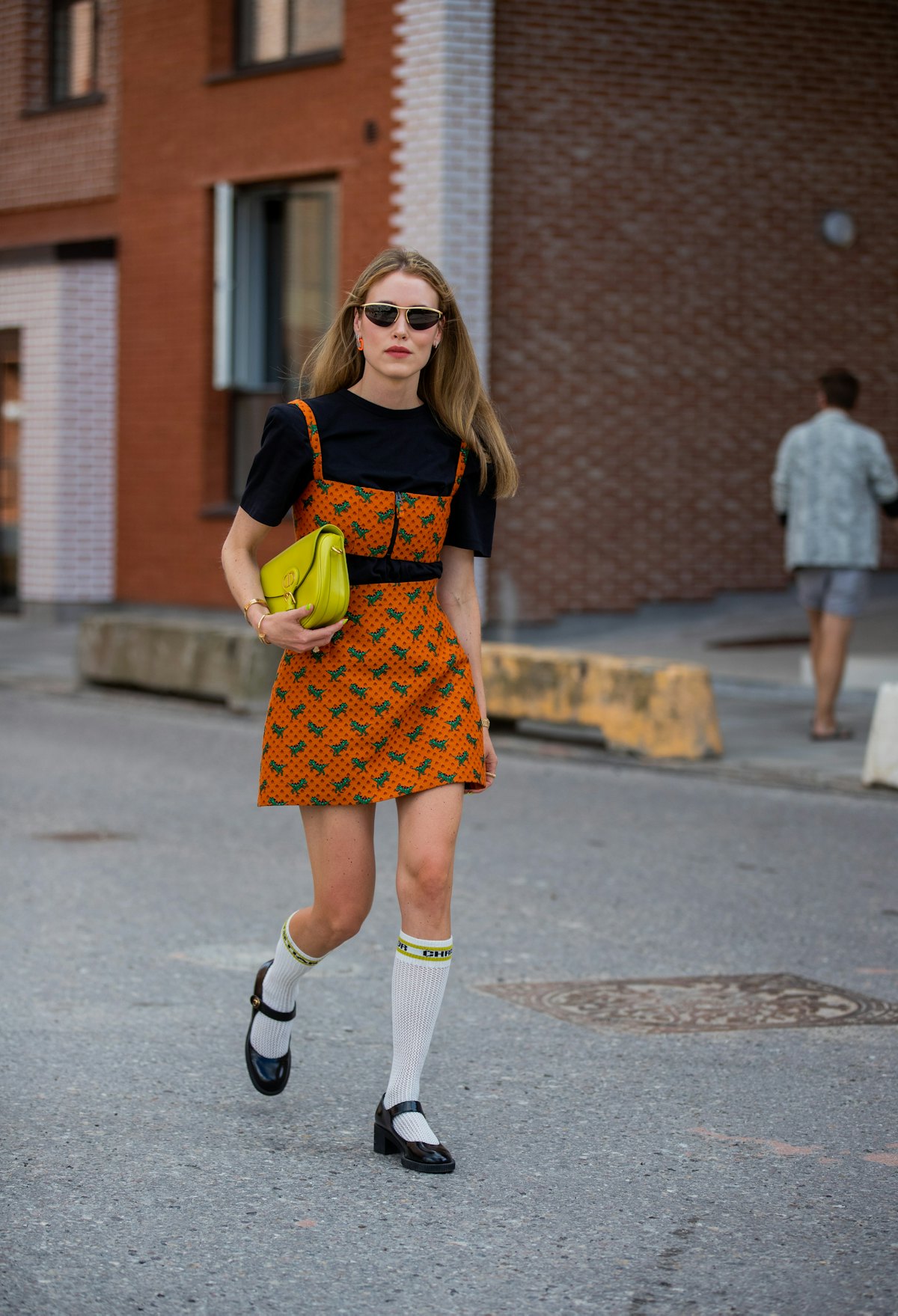 Annabel Rosendahl seen wearing orange dress with print, neon bag, knee socks and shoes outside Desig...